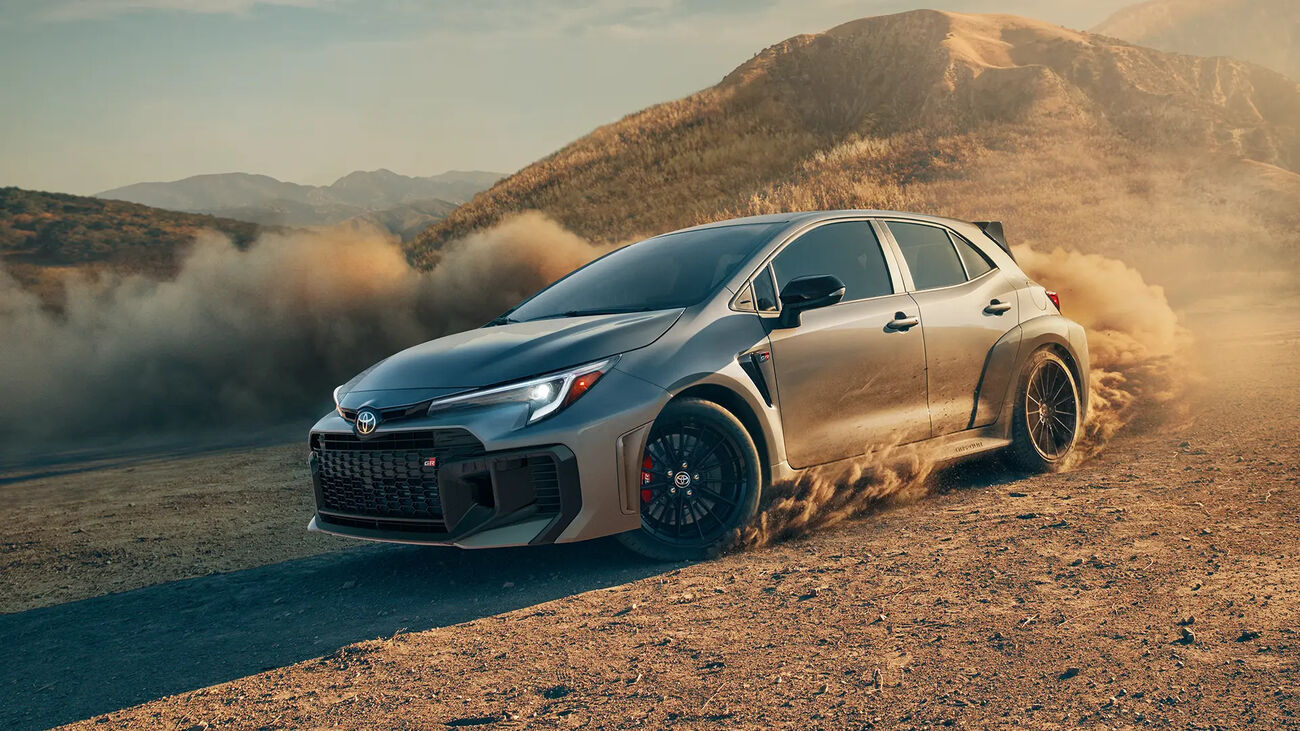 Toyota GR Corolla Premium Plus in Heavy Metal gliding through a dirt road corner followed by a cloud of dust